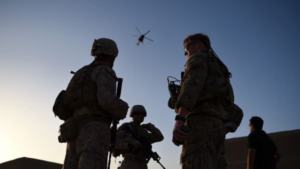 In this file photo taken on August 27, 2017 US Marines and Afghan Commandos stand together as an Afghan Air Force helicopter flies past during a combat training exercise at Shorab Military Camp in Lashkar Gah in Helmand province. The United States has secured a seven-day reduction in violence in talks to help seek a negotiated settlement in Afghanistan, Pentagon chief Mark Esper said February 13, 2020. The announcement came as NATO defence ministers met in Brussels and a day after Afghan President Ashraf Gh