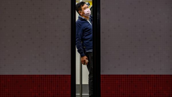 A man wears a face mask as a preventative measure against the COVID-19 coronavirus, as he stands in a train at Mong Kok MTR station in Hong Kong on February 14, 2020. The death toll from China's virus epidemic neared 1,400 on Friday with six medical workers among the victims, underscoring the country's struggle to contain a deepening health crisis. Philip FONG / AFP