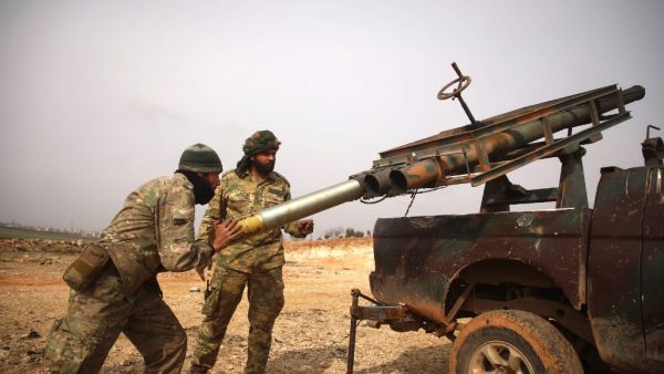 Turkish-backed Syrian fighters load a make-shift rocket launcher mounted on the back of a pickup truck in the village of Miznaz, on the western outskirts of Aleppo province, on February 14, 2020 as they prepare for a counter-offensive against advancing government forces in the Aleppo countryside. AAREF WATAD / AFP