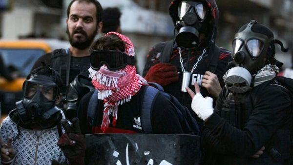 Iraqi protesters wear protective masks during clashes with riot police following an anti-government demonstration in the capital Baghdad's Al-Khilani Square, on February 14, 2020. AHMAD AL-RUBAYE / AFP