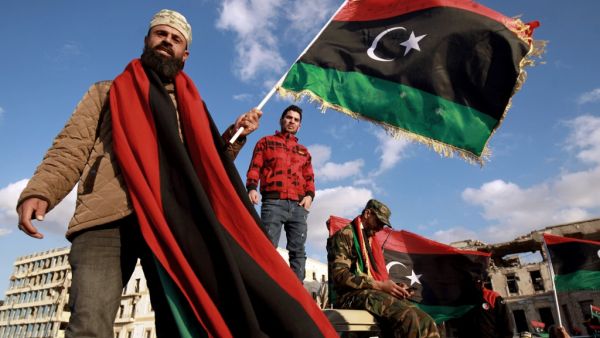Libyans wave their national flag as they take part in a celebration marking the Libyan revolution, which toppled strongman Moamer Kadhafi, in Benghazi on February 17, 2020. Abdullah DOMA / AFP 