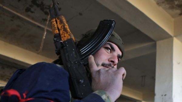 A Turkish-backed Syrian fighter carries a riffle at a position east of Idlib city in northwestern Syria on February 20, 2020 amid ongoing regime offensive on the last major rebel bastion in the country's northwest.  Bakr ALKASEM / AFP