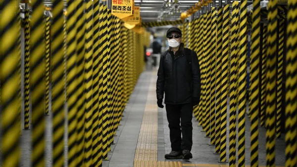 A man wearing a face mask walks between columns at a subway station being renovated in Seoul on February 22, 2020. AFP