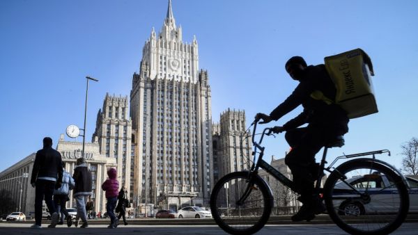 People walk and cycle past the Russian Foreign Ministry building in Moscow (AFP)