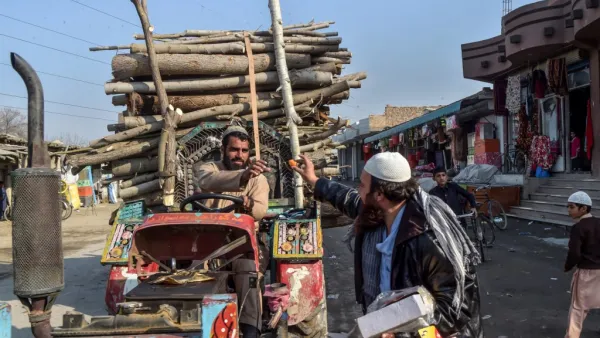 An Afghan refugee (R) distributes sweets to celebrate the 'reduction in violence' agreed earlier between Taliban, US and Afghan forces, in the Khurasan refugee camp on the outskirts of Peshawar on February 22, 2020. AFP