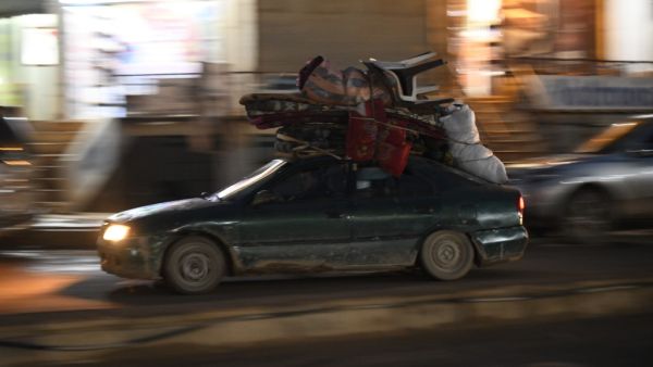 Displaced Syrians drive a car loaded with their belongings through the town of Atme, near the Turkish border in the northwestern Idlib province, on February 23, 2020. Rami al SAYED / AFP