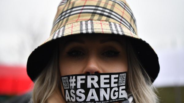 A supporter of WikiLeaks founder Julian Assange wearing tape on her mouth calling for his freedom  (AFP)