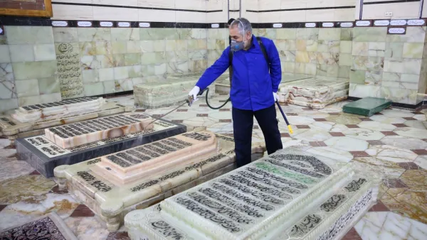 An Iranian sanitary worker disinfects Qom's Masumeh shrine on February 25, 2020 to prevent the spread of the coronavirus which reached Iran, where there were concerns the situation might be worse than officially acknowledged. AFP