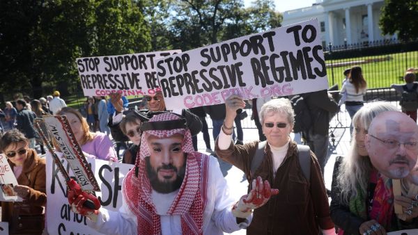 A protester dressed as Saudi Arabian crown prince Mohammad bin Salman, demonstrates with members of the group Code Pink outside the White House in the wake of the disappearance of Saudi Arabian journalist Jamal Khashoggi October 19, 2018 in Washington, DC. Khashoggi has disappeared following a meeting at the Saudi consulate in Istanbul on October 2, 2018. Win McNamee/Getty Images/AFP WIN MCNAMEE / GETTY IMAGES NORTH AMERICA / AFP