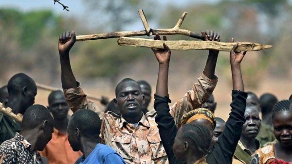 South Sudan trainee soldiers for a new unified army raise their wooden rifles above their heads while attending a reconciliation program on January 31, 2020, meant at ending bloodshed in the country. (AFP)