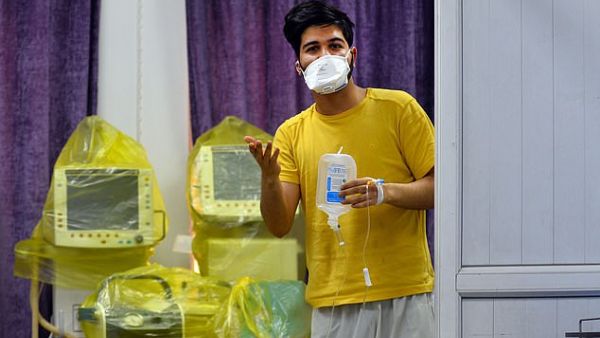 An Iranian student who is feared to be the first coronavirus patient in Iraq wears a mask and holds medical equipment at a hospital in Najaf in Iraq yesterday. AFP/File
