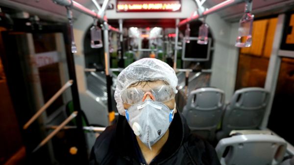 A Tehran Municipality worker cleans a bus to avoid the spread of the COVID-19 illness on February 26, 2020. Iran said Tuesday its coronavirus outbreak, the deadliest outside China, had claimed 15 lives and infected nearly 100 others -- including the country's deputy health minister. The Islamic republic's neighbours have imposed travel restrictions and strict quarantine measures after reporting their first cases in recent days, mostly in people with links to Iran. ATTA KENARE / AFP