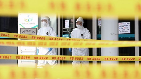 Medical staff members wearing protective gear move inside the yellow control lines at a hospital for patients infected with the COVID-19 coronavirus in Daegu on March 1, 2020. South Korean President Moon Jae-in said on March 1 the government was waging "all-out responses" to contain the novel coronavirus as the country reported 376 new cases, taking the total to 3,526. YONHAP / AFP