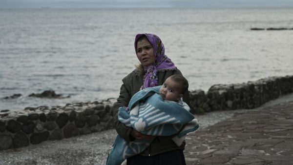 A migrant woman carries a toddler near Skala Sykamineas on the Greek Lesbos island after crossing the Aegean sea between Turkey and Greece on March 01, 2020. Greece has blocked nearly 10,000 migrants trying to enter at the Turkey border over the past 24 hours, a Greek government source said Sunday. "From 0600 (0400 GMT) Saturday morning to 0600 Sunday morning, 9,972 illegal entrances have been averted in the Evros area," a government source said, referring to the northeastern region along the Turkey border.