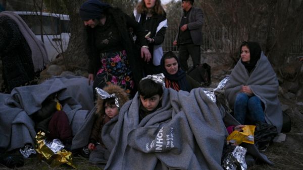 Migrants sit on a beach covered with blanket near Skala Sykamineas on the Greek Lesbos island after crossing the Aegean sea between Turkey and Greece on March 1, 2020. Greece has blocked nearly 10,000 migrants trying to enter at the Turkey border over the past 24 hours, a Greek government source said Sunday. "From 0600 (0400 GMT) Saturday morning to 0600 Sunday morning, 9,972 illegal entrances have been averted in the Evros area," a government source said, referring to the northeastern region along the Turk