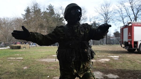 Greek army officer gestures on the Greek side of the Greece-Turkey border near Kastanies, on March 2, 2020. Greece was on a state of alert on March 1, 2020 as it faced an influx of thousands of migrants seeking to cross the border from Turkey, with locals fearing a new immigration crisis. More than 13,000 migrants have gathered on the Turkish side of the river which runs 200 kilometres (125 miles) along the frontier and separates them from Greece and therefore the European Union. The flow of migrants from T