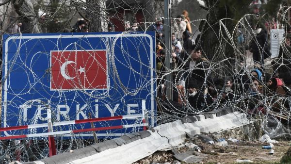 This picture taken from the Greek side of the Greece-Turkey border near Kastanies, shows migrants waiting on the Turkish side on March 2, 2020. Greece was on a state of alert on March 1, 2020 as it faced an influx of thousands of migrants seeking to cross the border from Turkey, with locals fearing a new immigration crisis. More than 13,000 migrants have gathered on the Turkish side of the river which runs 200 kilometres (125 miles) along the frontier and separates them from Greece and therefore the Europea