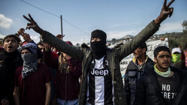 Migrants and refugees take part in a demonstration following clashes with Greek riot police near the Moria camp for refugees and migrants on the island of Lesbos on March 2, 2020. More than 13,000 migrants have gathered on the Turkish side of the river which runs 200 kilometres (125 miles) along the frontier and separates them from Greece and therefore the European Union. The flow of migrants from Turkey has triggered EU fears of a re-run of the 2015 migrant emergency when Greece became the main EU entry po