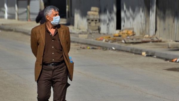 An Iraqi man wearing a protective mask walks in a deserted street in the northern Iraqi city of Mosul on March 3, 2020 amid fears of the spread of the coronavirus across Iraq. Iraq reported its first coronavirus case last week in an Iranian national studying at a religious seminary in the southern shrine city of Najaf. The total number of diagnosed infections has since jumped to 19 -- all traced to the Islamic republic, just across the border. This has sparked public panic in Iraq, one of Iran's largest exp