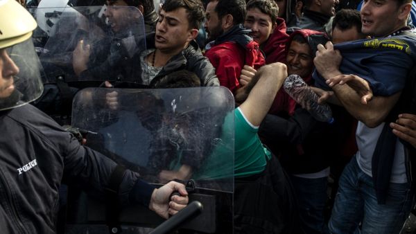 Migrants and refugees scuffle with riot police on the Greek Aegean island of Lesbos, on March 3, 2020, amid a migration surge from neighbouring Turkey after it opened its borders to thousands of refugees trying to reach Europe. Several aid groups on Greece's Lesbos said they were suspending work with refugees and evacuating staff on March 3 in the wake of violence and threats, as tensions soar on an island in the crosshairs of the migrant crisis. EU chiefs pledged millions of euros of financial assistance t
