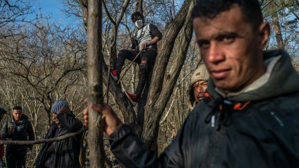 Migrants wait at the buffer zone in front of the Pazarkule border crossing to Greece, in Edirne on March 3, 2020. Migrants and refugees hoping to enter Greece from Turkey appeared to be fanning out across a broader swathe of the roughly 200-kilometer-long land border on March 3, 2020, maintaining pressure on the frontier after Ankara declared its borders with the European Union open. BULENT KILIC / AFP