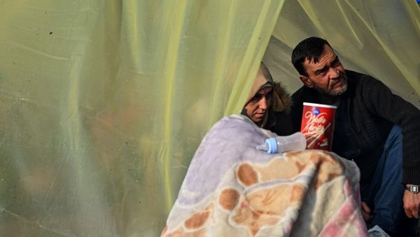 Migrants sit in a make shift shelter as they gather near the Tunca river waiting to resume their efforts to enter Europe near Pazarkule border gate in the city of Edirne, northwest Turkey on March 5, 2020. EU members on March 4, 2020 rejected what they said is Turkey's use of desperate migrants to pressure its neighbours -- and strongly backed Greece's border crackdown. The EU has scrambled to respond to the surge of migrants at the Greek border, where authorities say some 24,000 were stopped from entering 