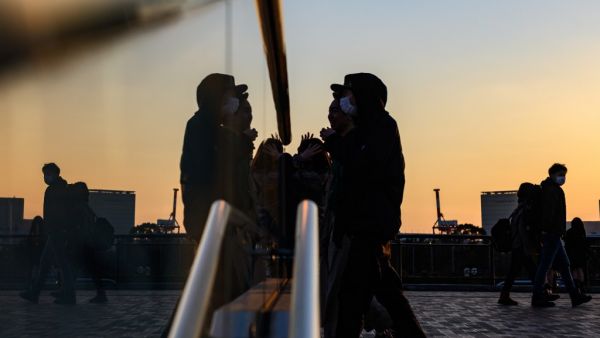People wearing face masks walk at the Odaiba Seaside Park in Tokyo on March 6, 2020. Construction of all new permanent venues for the Tokyo 2020 Olympics and Paralympics is now complete, organisers said on March 6, as preparations continue despite worries over the COVID-19 coronavirus outbreak. Philip FONG / AFP