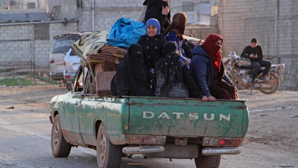 Syrians ride in the back of a truck in the town of Hazano in the rebel-held northern countryside of Syria's Idlib province on March 7, 2020. Ibrahim YASOUF / AFP