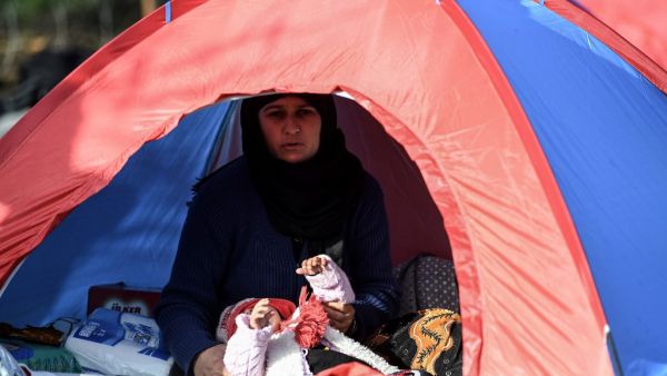 A woman and her baby are pictured in a tent at a migrants' makeshift camp near a bus terminal, as they wait to resume their efforts to enter Europe near Pazarkule border gate in the city of Edirne, northwest Turkey on March 8, 2020. EU members on March 4, 2020 rejected what they said is Turkey's use of desperate migrants to pressure its neighbours -- and strongly backed Greece's border crackdown. The EU has scrambled to respond to the surge of migrants at the Greek border, where authorities say some 24,000 