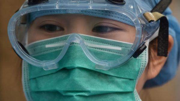 A medical worker wearing protective clothing as a preventive measure against the COVID-19 coronavirus, stands at Xuhui District Hospital in Shanghai on March 9, 2020 China reported 22 new deaths on March 9 from the new coronavirus epidemic, and the lowest number of fresh cases since it started reporting the data in January. Hector RETAMAL / AFP