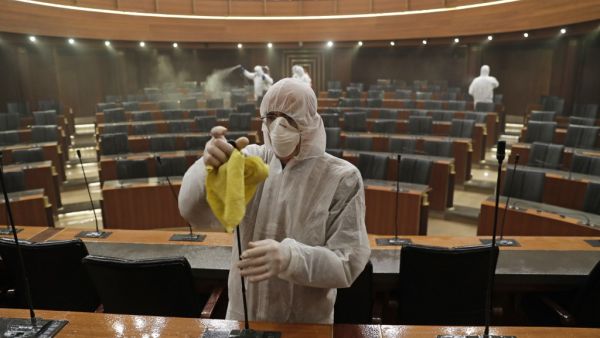 Sanitary workers disinfect the desks and chairs of the Lebanese Parliament in central Beirut on March 10, 2020 amid the spread of coronavirus in the country. ANWAR AMRO / AFP