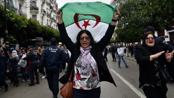 An Algerian woman waves a national flag as she takes part in an anti-government demonstration in the capital Algiers on March 14, 2020. RYAD KRAMDI / AFP
