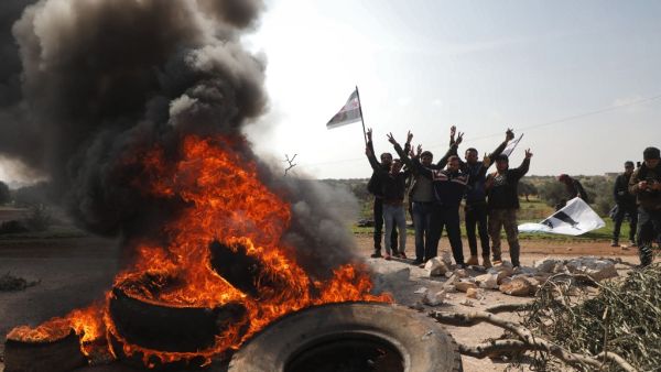 Syrians protest and burn tyres in an attempt to block traffic on the M4 highway, which links the northern Syrian provinces of Aleppo and Latakia, before incoming joint Turkish and Russian military patrols (as per an earlier agreed upon ceasefire deal) in the village of al-Nayrab, about 14 kilometres southeast of the city of Idlib and seven kilometres west of Saraqib in northwestern Syria on March 15, 2020. AFP/File