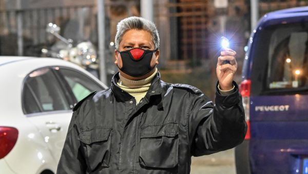 A man wearing a face mask holds a light during a flash mob " Italia Patria Nostra" (Italy Our Country) at the Garbatella district in Rome on March 15, 2020. Italy reacts with the solidarity of flash mobs circulating on social media to make people "gather" on balconies at certain hours, to show lights, candles, flashlights or smartphones's light. AFP/File