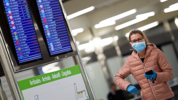 A woman wearing a face mask walks at the airport in Palma de Mallorca on March 16, 2020. Spain has registered nearly 1,000 new COVID-19 infections over the past 24 hours, raising the total number of cases to 8,744. AFP/File