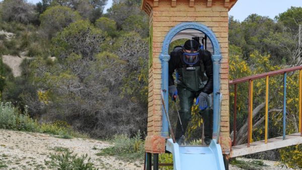 A health worker disinfects the Enahli amusement park on March 16, 2020 at Ariana near Tunis, which has been closed to the public from today during the coronavirus COVID-19 pandemic. A decision was made today by the authorities to ban parties, parks, weekly souks and all sporting activities. FETHI BELAID / AFP
