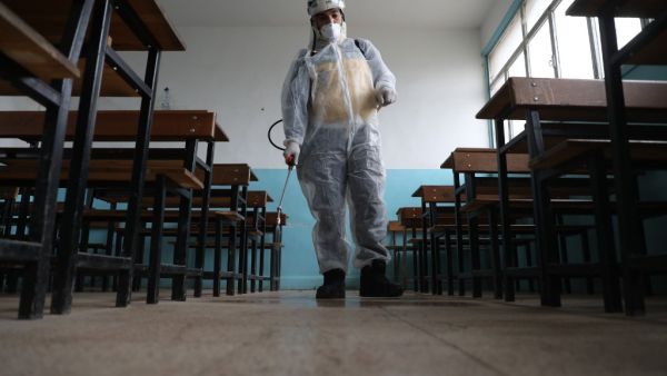 A member of the Syrian Civil Defence, also known as the "White Helmets", helped by a Turkish health organisation, sterilises a school in the area of Ghosn al-Zeitun in Afrin on March 18, 2020 as part of a campaign to disinfect schools against the coronavirus COVID-19 in the Afrin region of the northern Syrian province of Aleppo, controlled by Turkey-backed opposition groups.  AAREF WATAD / AFP