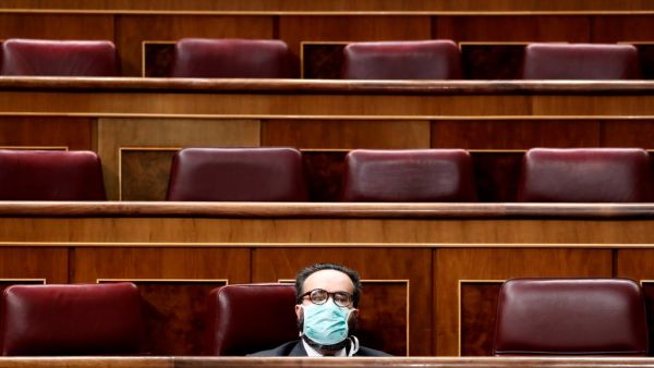 Spanish far-right Vox party's MP Jose Maria Sanchez Garcia wears a face mask as a protective measure during a session at the Spanish Parliament in Madrid to explain the Government's declaration of a State of Alert and the measures taken to mitigate the coronavirus COVID-19 consequences on March 18, 2020. The Prime Minister, Pedro Sanchez, warned today that "the hardest is yet to come" when the number of people in hospitals due to the coronavirus increases, before a practically empty Congress to avoid spread