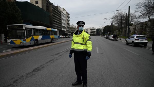 A Greek police officer stands in a deserted street of Athens to control motorists and pedestrians, on March 23, 2020 as the country is battling hard to control the spread of the COVID-19, the novel coronavirus. Aris MESSINIS / AFP