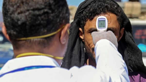 A health official checks the body temperature of man at the entrance of the city of Taez in southwestern Yemen on March 23, 2020 amid concerns over the spread of the COVID-19 novel coronavirus. Ahmad AL-BASHA / AFP