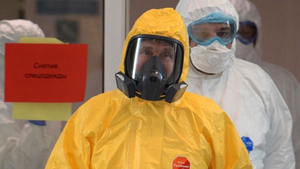 Russian President Vladimir Putin wearing protective gear visits a hospital where patients infected with the COVID-19 novel coronavirus are being treated in the settlement of Kommunarka in Moscow on March 24, 2020. Alexey DRUZHININ / SPUTNIK / AFP