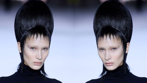 Bella took to the runway in a black form-fitting polo neck and satin pleated culottes