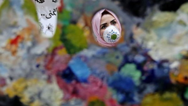 Gazan artist wears a face mask to raise awareness to the novel coronavirus (Twitter)