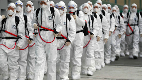 South Korean soldiers wearing protective gear move to spray disinfectant against the spread of the coronavirus at a railway station in Daegu on February 29, 2020. © YONHAP / AFP