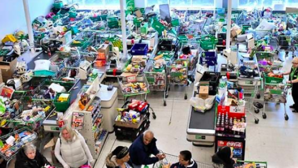 Trolleys piled high for delivery are seen as shoppers queue at the checkout of a supermarket in London on Mar 14, 2020, as consumers worry about product shortages, leading to the stockpiling of household products due to the outbreak of the novel coronavirus COVID-19. (Photo: AFP)