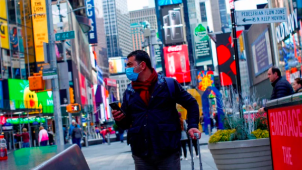 A man visits Times Square as he wears a face mask on March 8, 2020 in New York City, (AFP)