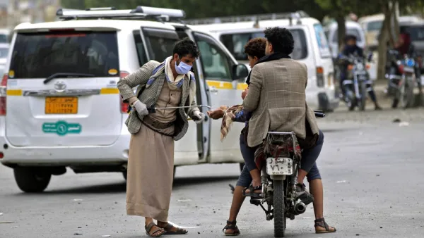 A Yemeni volunteer disinfects the hands of a man driving a motorcycle in the capital Sanaa, amid concerns over the spread of the novel coronavirus, on March 28, 2020. Yemen's broken healthcare system has not so far recorded a case of the COVID-19 illness, but aid groups have warned that when it does hit, the impact will be catastrophic in a country already regarded as facing the world's worst humanitarian crisis. Mohammed HUWAIS / AFP