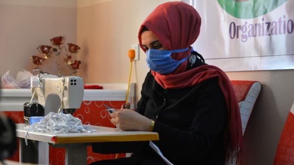 An Iraqi woman sews protective masks at a workshop sponsored by a local relief oranisation in the northern Iraqi city of Mosul on April 1, 2020 amid an increasing need in Iraq for masks for protection against the spread of the coronavirus COVID-19 pandemic. Zaid AL-OBEIDI / AFP