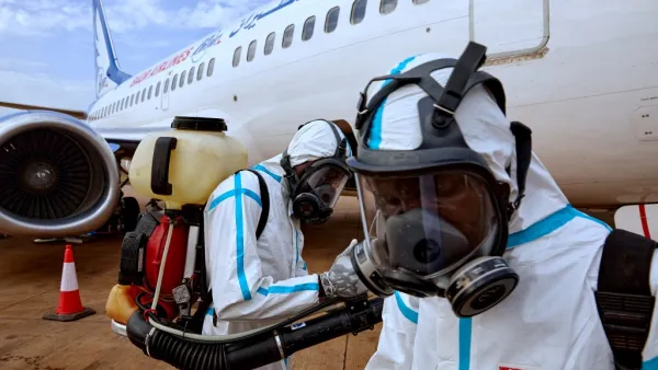 Airport staff members prepare to disinfect a plane after it landed at Juba International Airport in Juba, South Sudan on April 3, 2020. An aircraft that landed in Juba was disinfected of any potential traces of the COVID-19 coronavirus after carrying passengers who had recently arrived in South Sudan from neighbouring Sudan. Alex McBride / AFP