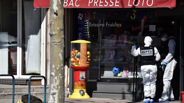 A French Police Judiciaire officer wearing a protective suits holds a camera on a tripod in the centre of Romans-sur-Isere, on April 4, 2020, after a man attacked several people with a knife, killing two and injuring seven before being arrested, according to sources close to the investigation. JEFF PACHOUD / AFP